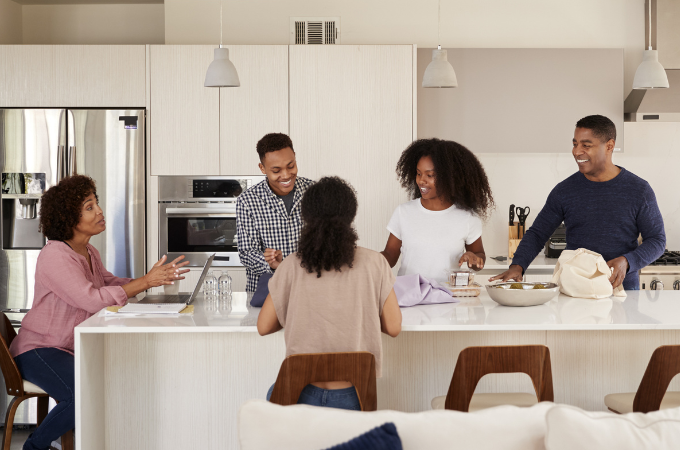family with three teenagers having a family meeting in their kitchen