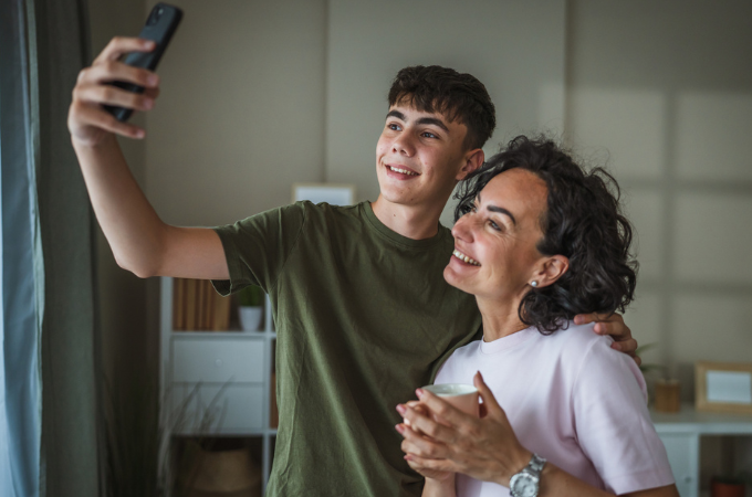 happy mother and teenage son with son taking selfie of the two; concept of connection first parenting or what is emotional safety